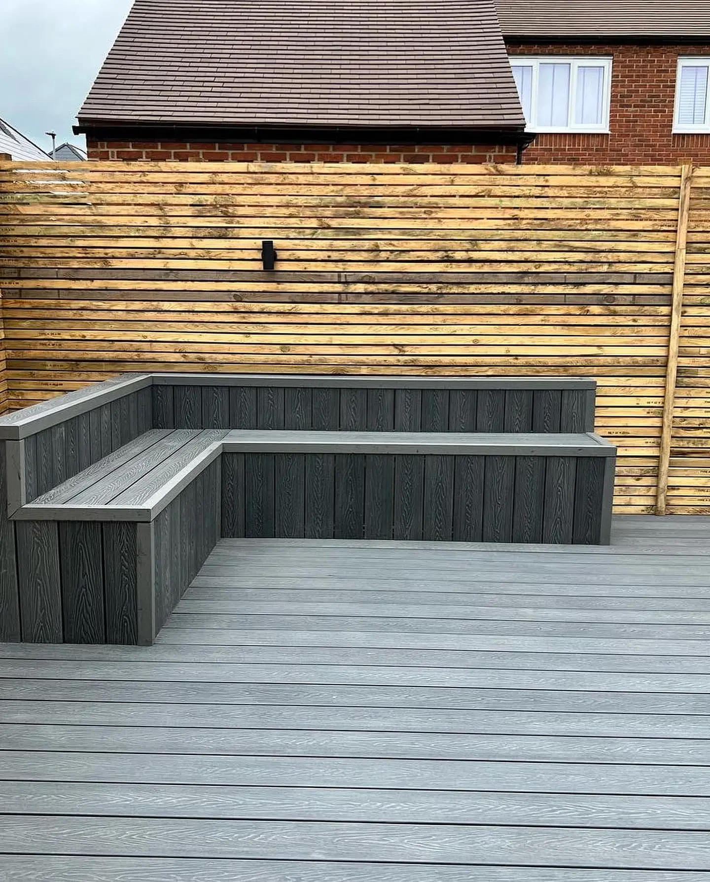 Grey composite decking with built-in bench seating completed by JDS Landscaping in Suffolk