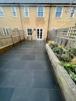 Dark porcelain paving with sleeper raised beds and planting