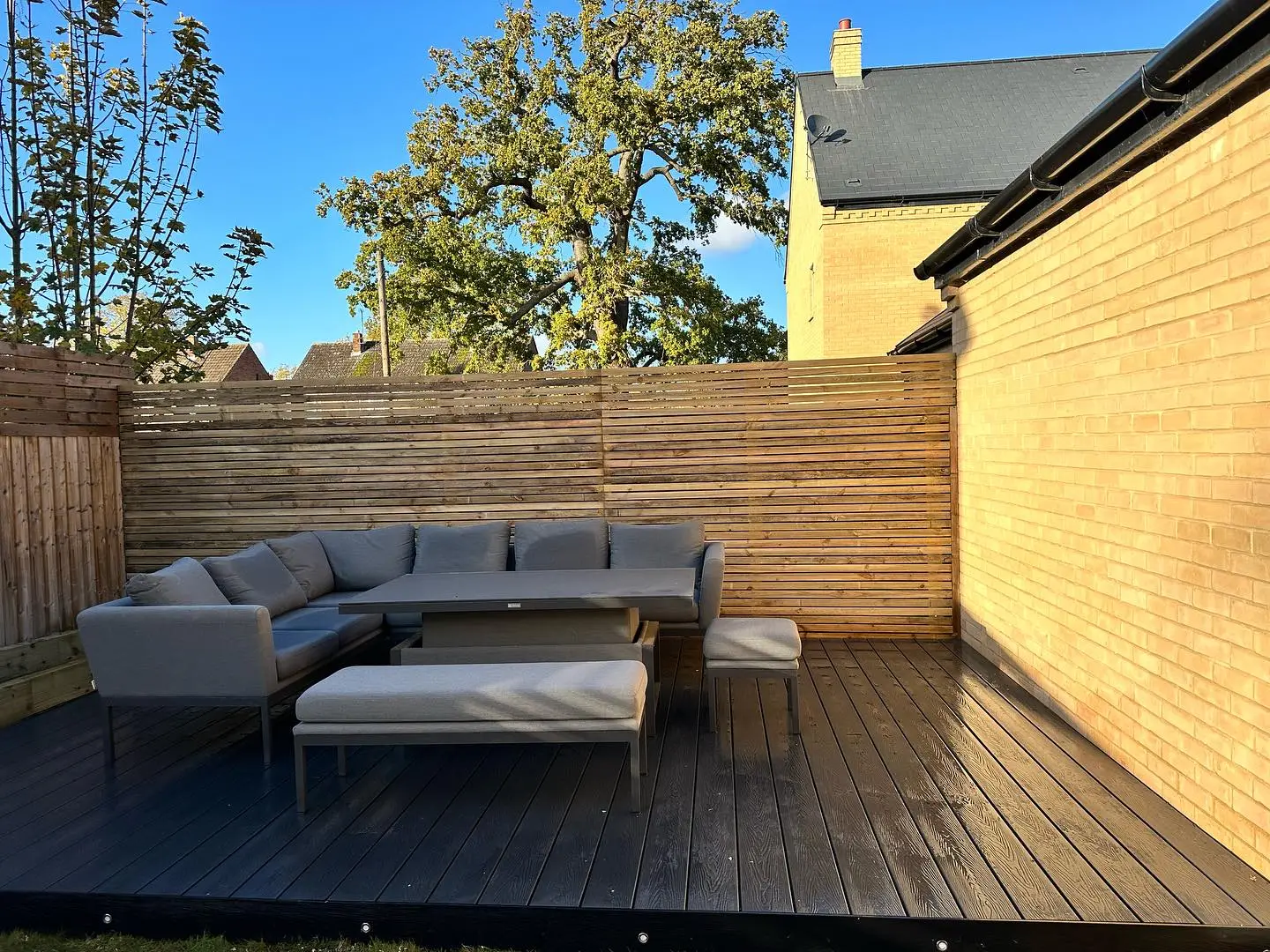 Composite decking and outdoor lounge seating in a garden transformed by JDS Landscaping in Suffolk