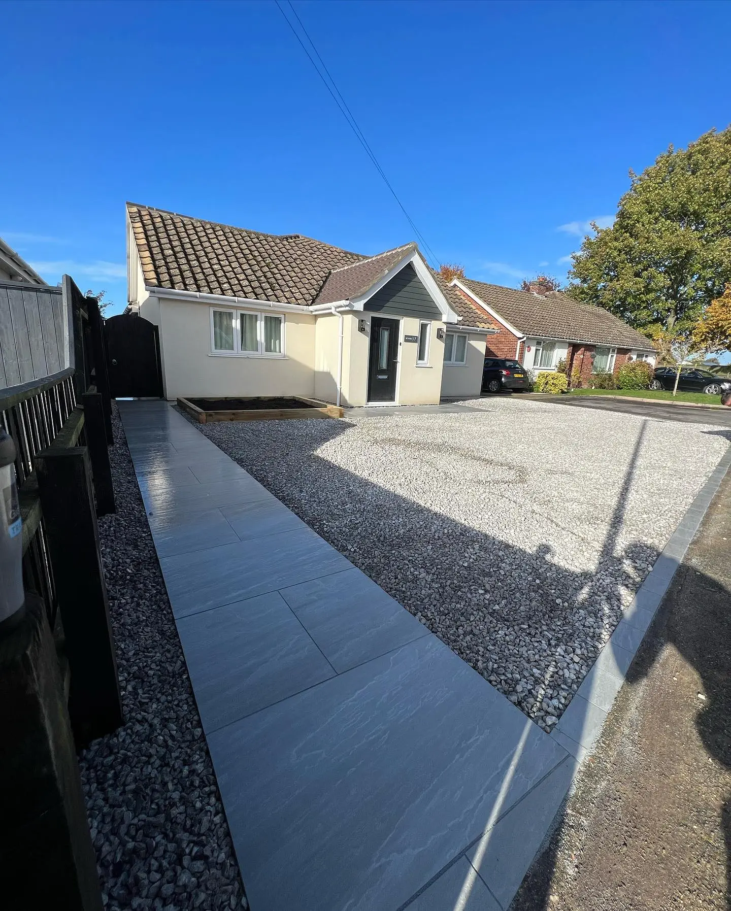 Gravel driveway with porcelain paved path at a home landscaped by JDS in Cambridgeshire